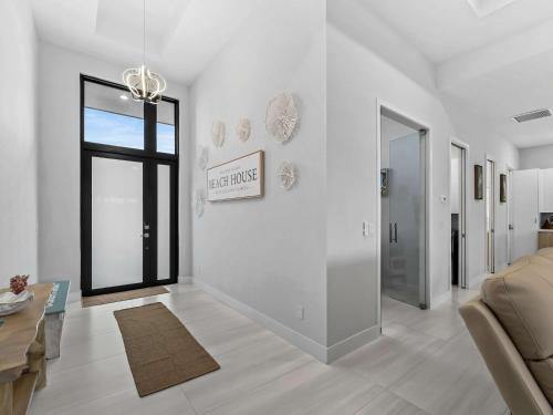 a white living room with a couch and a window at Waterfront Haven with Pool Spa Game Room in Port Charlotte