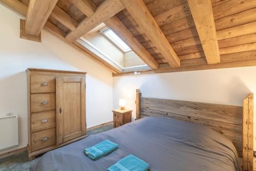 a bedroom with a large bed and a skylight at Les Petits Loups in Morillon
