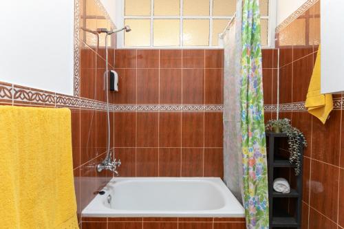 a bathroom with a tub and a shower curtain at Arenas de Sal in La Mareta