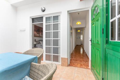 a green door in a room with a table and chairs at Arenas de Sal in La Mareta