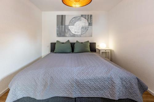 a bedroom with a large bed with green pillows at Stegmann Horn in Gaienhofen