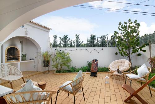a patio with chairs and a white wall at Casa Judite in Lagoa