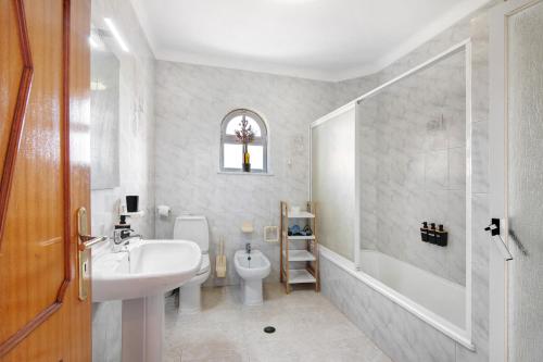 a bathroom with a sink and a toilet and a shower at Casa Judite in Lagoa