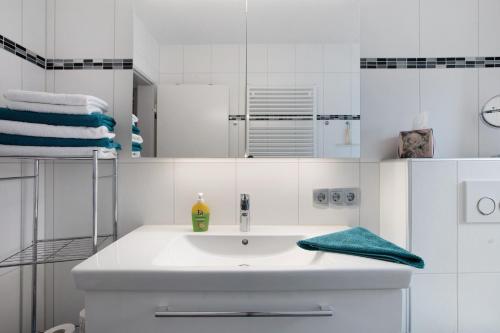 a white bathroom with a sink and a mirror at Ferienwohnung Barbara in Karsau