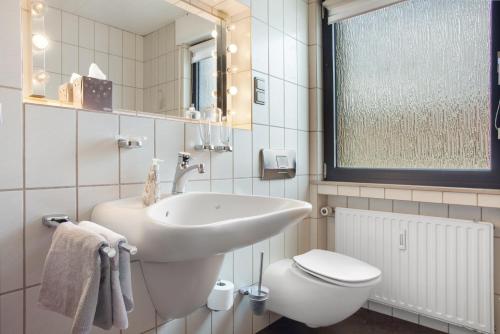 a bathroom with a sink and a toilet at Ferienwohnung Lux in Plettenberg