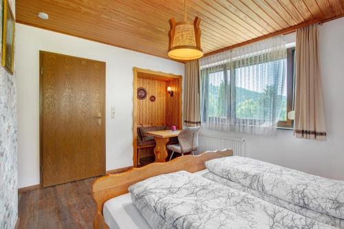 a bedroom with a bed and a desk and a table at Am Wehrastrand App Pr in Todtmoos