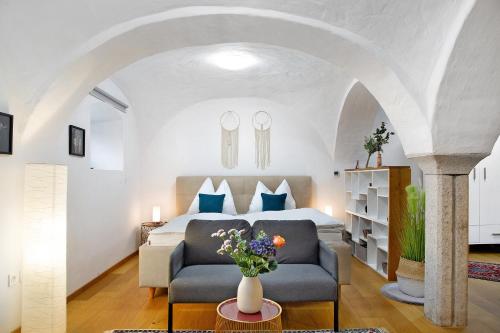 a bedroom with a bed and a couch and a table at Schönauer Hof - Wohnung Paula in Passau