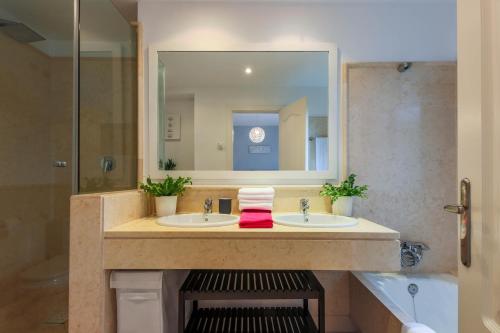 a bathroom with two sinks and a large mirror at 2-bed apt in Capanes del Golf in Benahavís