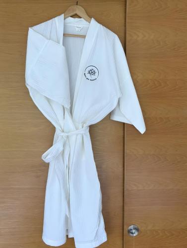 a white robe is hanging on a wooden wall at Maison Gaia in Valdeblore