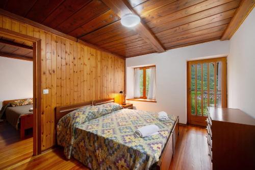 a bedroom with a bed in a room with wooden walls at Luéisch Ketschu near Gressoney in Issime