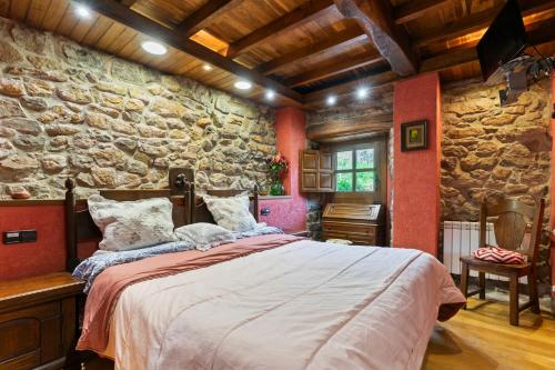 a bedroom with a large bed in a stone wall at La Casa De La Torre in Dosango