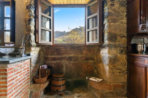 a bathroom with a tub with a window and a barrel at La Casa De La Torre in Dosango