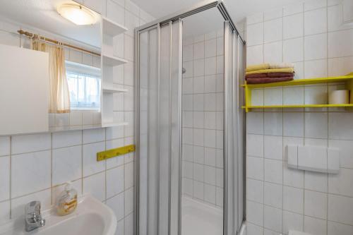 a white bathroom with a shower and a sink at Möve Aba Bungalow 65 in Rerik