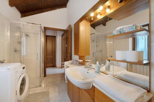 a bathroom with a sink and a washing machine at La mansarda di Mariuccia in Castelletto sopra Ticino