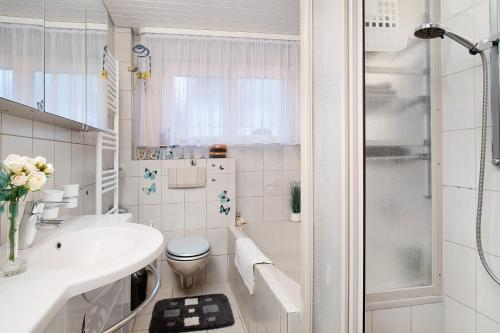 a white bathroom with a toilet and a shower at Ferienwohnungen Michael u Christine in Langenargen