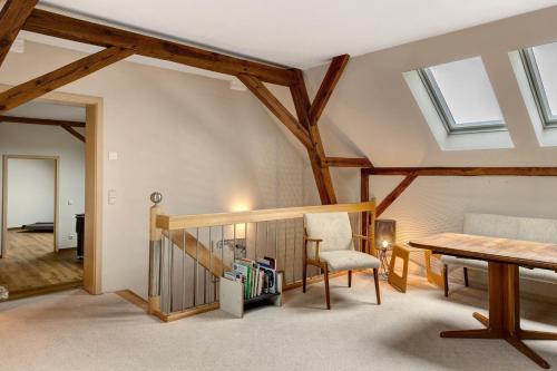 a room with wooden beams and a table and chair at Vierseitenhof mit Pool in Ziesar