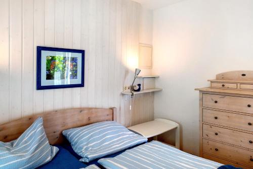 a small bedroom with a bed and a dresser at Möve Aba Bungalow 68 in Rerik