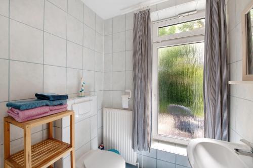 a bathroom with a sink and a toilet and a window at Möve Aba Bungalow 68 in Rerik
