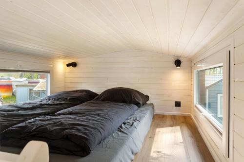 a bed in a tiny house with a ceiling at Tiny House Nr 6 in Schwielowsee