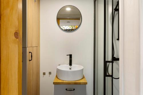 a bathroom with a white sink and a mirror at Tiny House Nr 6 in Schwielowsee