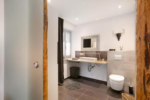 a white bathroom with a sink and a toilet at Schöne Altstadtwohnung In Neuruppin in Neuruppin