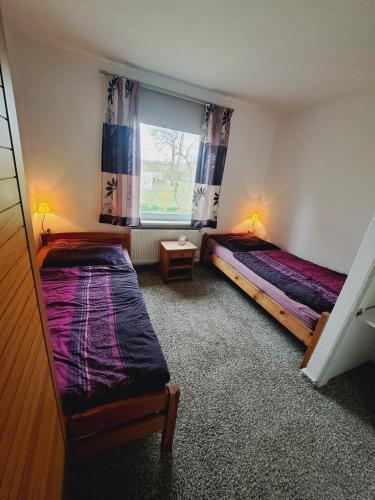 a bedroom with two beds and a window at Heidtschmidhof Gästehaus in Wolgast