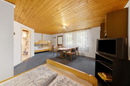 a living room with a couch and a tv and a table at Bungalow 2 - Kimbucht in Reichendorf