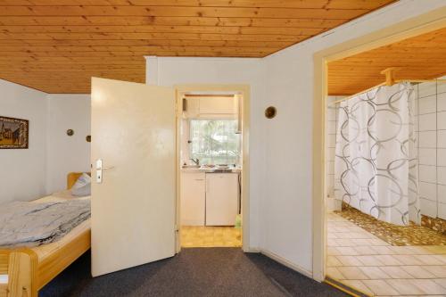 a bedroom with a bed and a door to a bathroom at Bungalow 2 - Kimbucht in Reichendorf