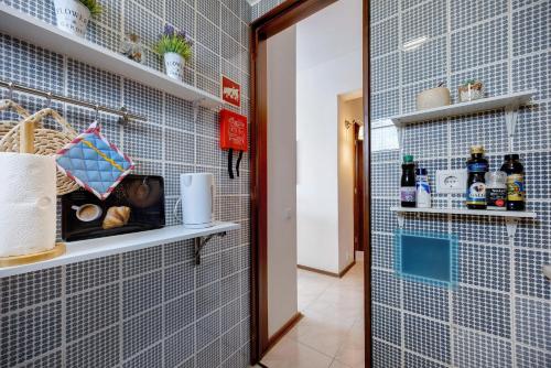 a bathroom with blue tiled walls and a mirror at Casa Pôr do Sol in Alvor