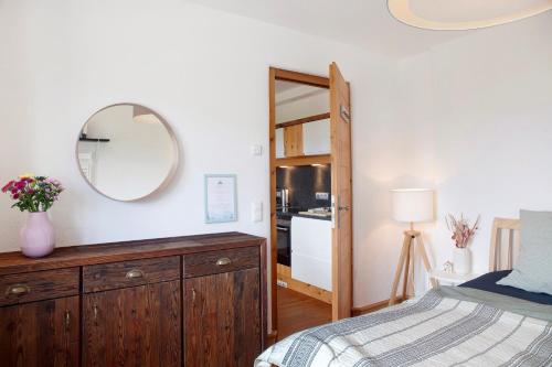 a bedroom with a wooden dresser and a mirror at Bergnest Penning in Hopfgarten im Brixental