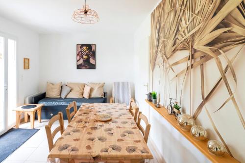 a dining room with a table and a couch at Cosy Pavillon 2chambres proche mer in Ondres
