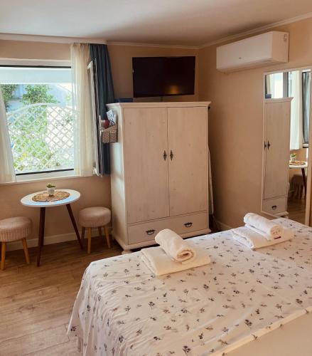 a bedroom with a bed and a cabinet with towels on it at Cozy Room in Mlini