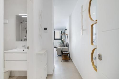 a white bathroom with a sink and a mirror at Apartamento Bambú 2 10 in Tarifa