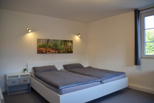 a bedroom with a bed and a painting on the wall at Ferienwohnung in Lichtenau