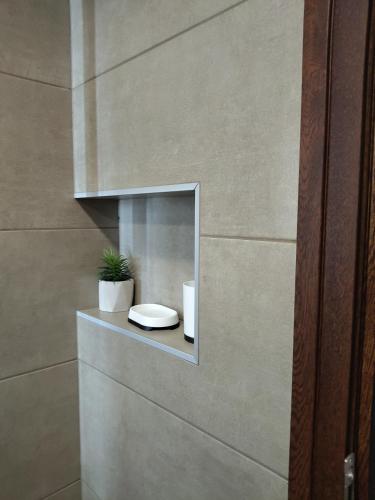 a bathroom with a niche with a toilet and a plant at Chergata Guest House in Zheglitsa