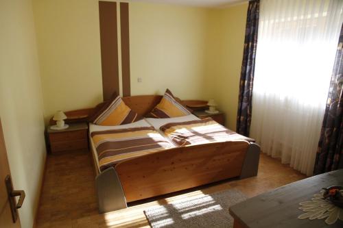 a bedroom with a wooden bed with a window at Ferienwohnung Stark in Scheßlitz