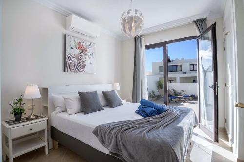 a white bedroom with a bed and a balcony at Casa Dubh Linn in Playa Blanca
