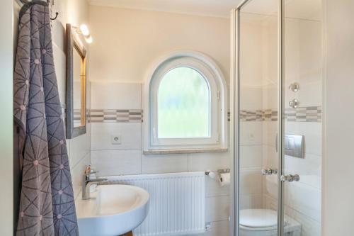 a bathroom with a sink and a toilet and a window at Ferienwohnung Kleisl in Grainau
