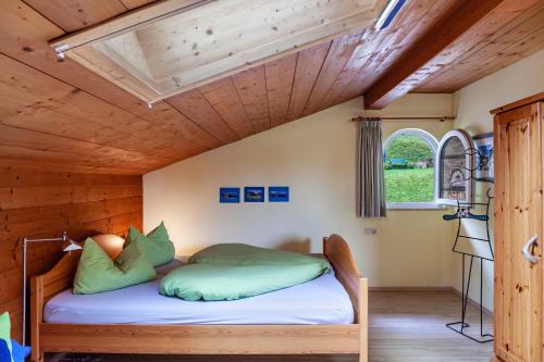 a bed in a room with a wooden ceiling at Ferienwohnung Kleisl in Grainau