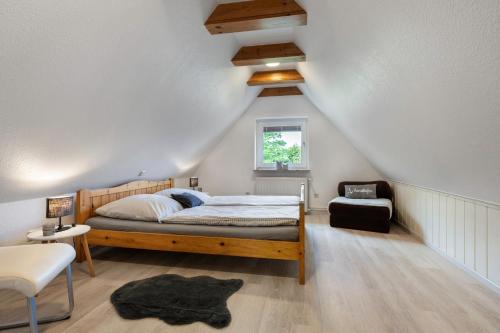 a bedroom with a wooden bed and a chair at Ferienwohnung Tüchsen in Klixbüll