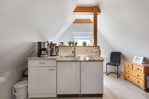 a kitchen with a sink in a attic at Ferienwohnung Tüchsen in Klixbüll