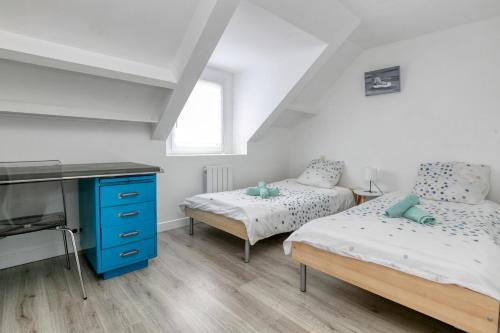 una camera da letto con due letti singoli e una TV di Seabird a Camoël