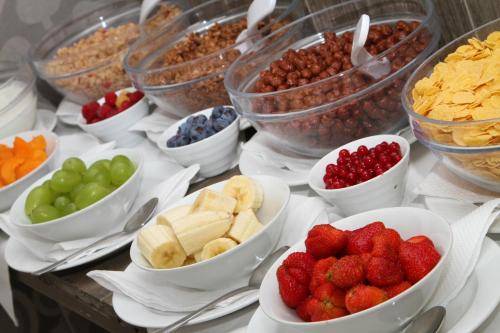 a table topped with bowls of fruit and other snacks at Hotel Bílý jednorožec in Třeboň