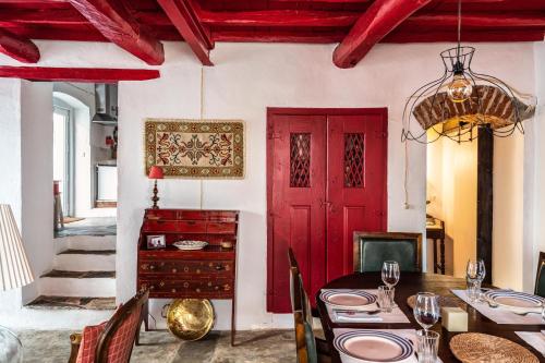 a dining room with a red door and a table at Casa do Pelourinho in Avis