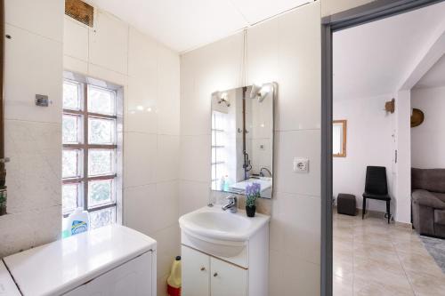 a white bathroom with a sink and a mirror at Cal Jaume in Masquefa
