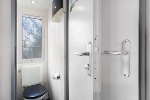 a bathroom with a toilet and a window at Bungalow T3 I V- 15 Min From Nazaré in Pataias