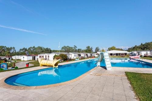 a large swimming pool with a slide in a park at Bungalow T3 I V- 15 Min From Nazaré in Pataias