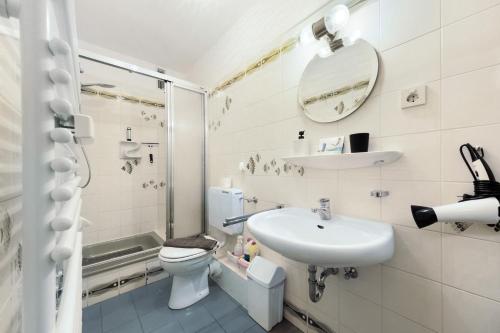 a white bathroom with a sink and a toilet at Haus Elbe 5 in Cuxhaven