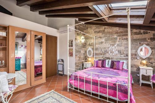 a bedroom with a pink bed in a room at Le Case di Erminia Vintage Valeggio in Valeggio sul Mincio