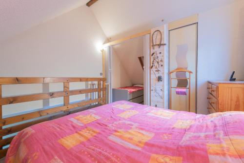 a bedroom with a bed with a pink comforter at Chalet 4 Personnes classé 3 étoiles in Luz-Saint-Sauveur